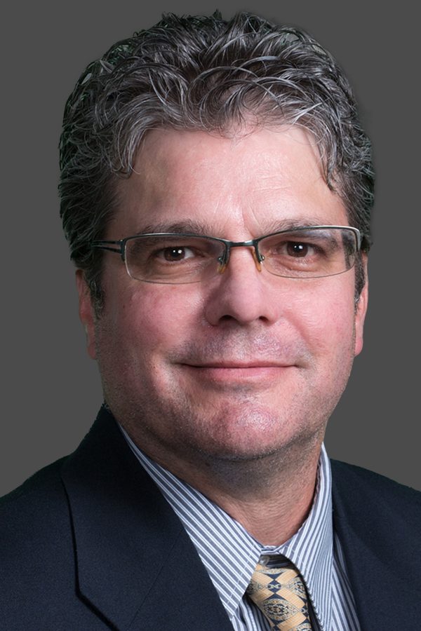 Adult male professional headshot on a blue background