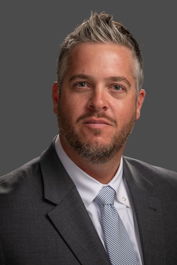 Adult male professional headshot on a blue background